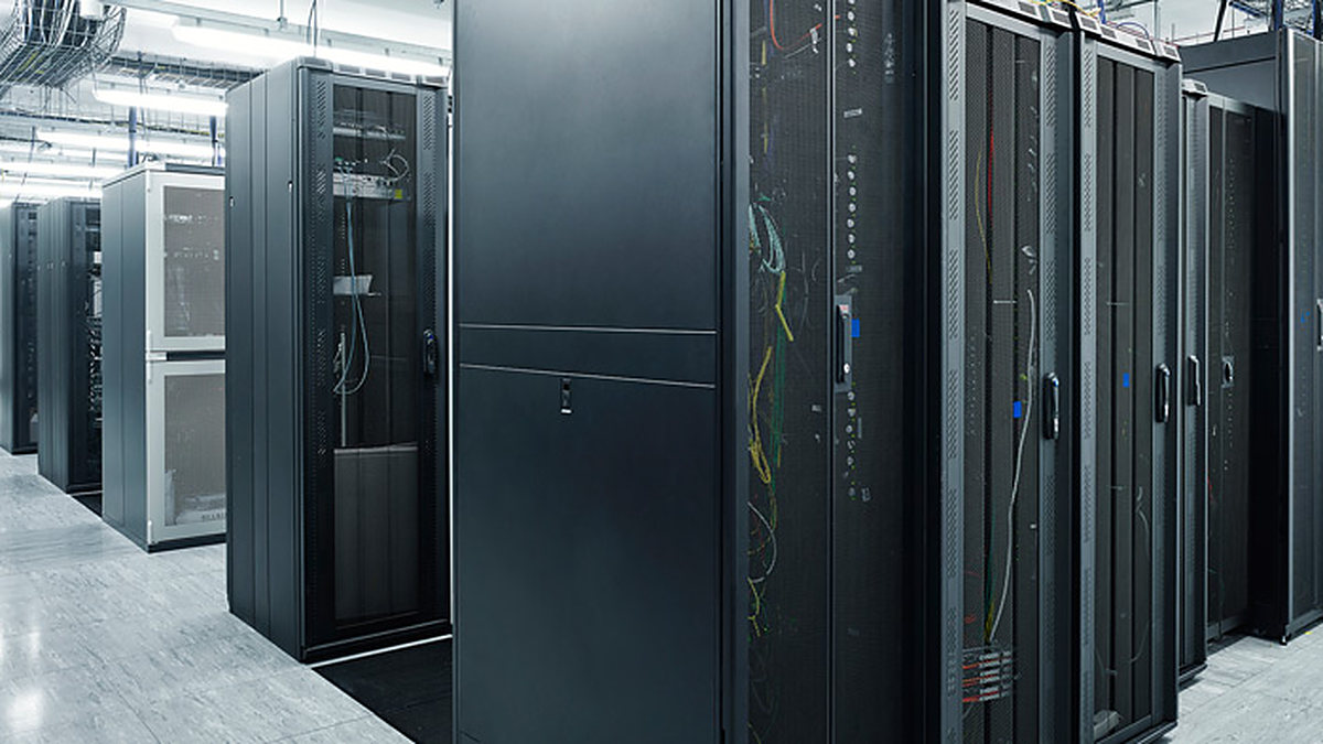 Rows of black server racks with cabling in a data center aisle